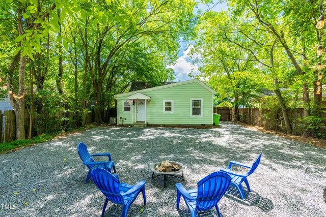 a backyard of a house with barbeque oven table and chairs
