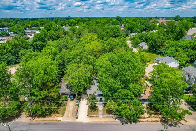 an aerial view of a house with lots of residential buildings and green space