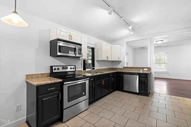 a kitchen with stainless steel appliances granite countertop a stove top oven a sink dishwasher and a microwave oven on the blue kitchen countertops