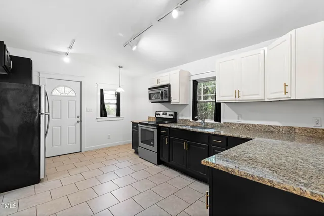 a kitchen with a sink refrigerator and cabinets