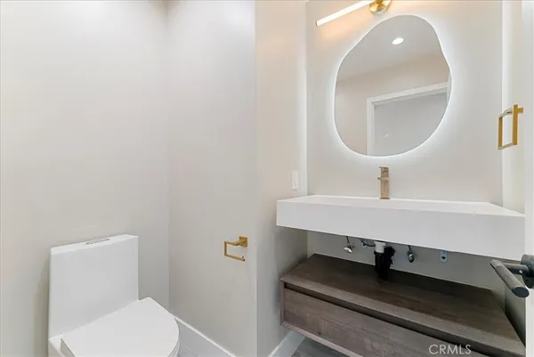 a bathroom with a toilet a sink and mirror