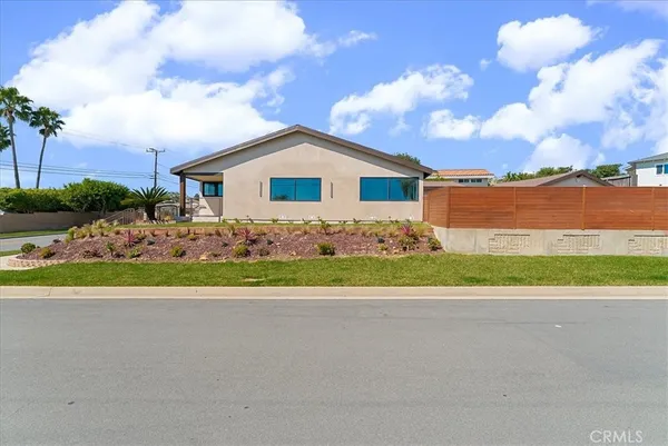 a front view of a house with a yard and potted plants