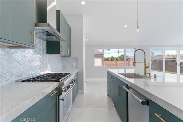 a kitchen with stainless steel appliances granite countertop a sink a stove and a refrigerator