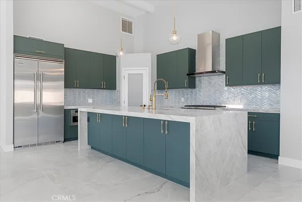 a kitchen with stainless steel appliances granite countertop a refrigerator and a sink