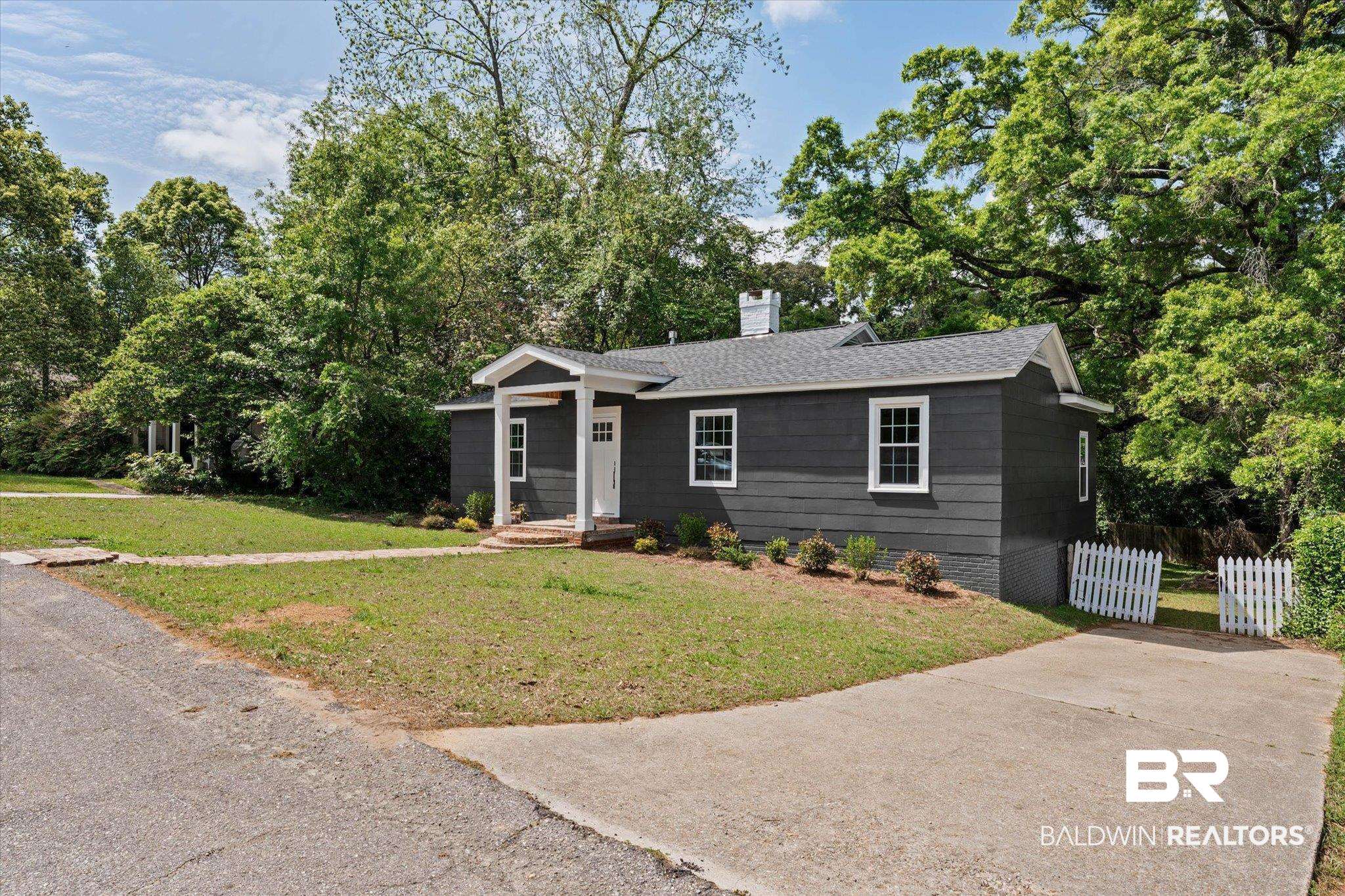 41 Hathaway Road West Mobile, AL 36608 - Photo 23 of 24 Ranch-style home with roof with shingles, a chimney, and view of wooded area