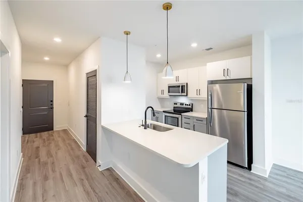 a kitchen with kitchen island white cabinets and stainless steel appliances