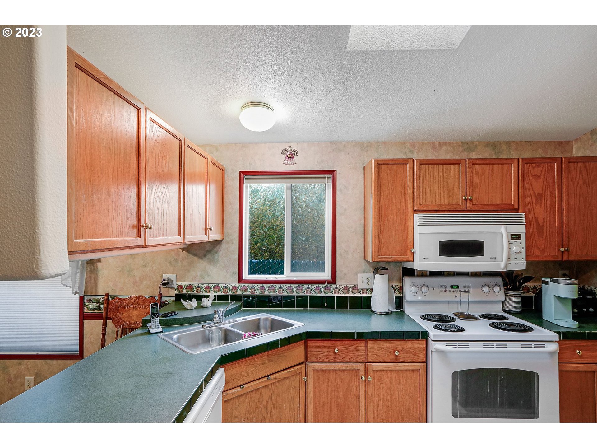 1015 Oak Street, Unit 100 Silverton, OR 97381 - Photo 8 of 30 a kitchen with stainless steel appliances granite countertop a stove a sink and a microwave
