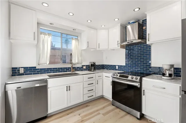 a kitchen with stainless steel appliances granite countertop a stove sink and cabinets