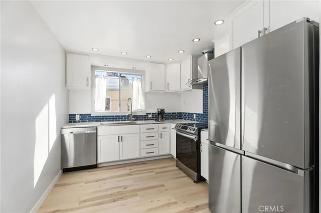 a kitchen with stainless steel appliances granite countertop a refrigerator and a stove top oven