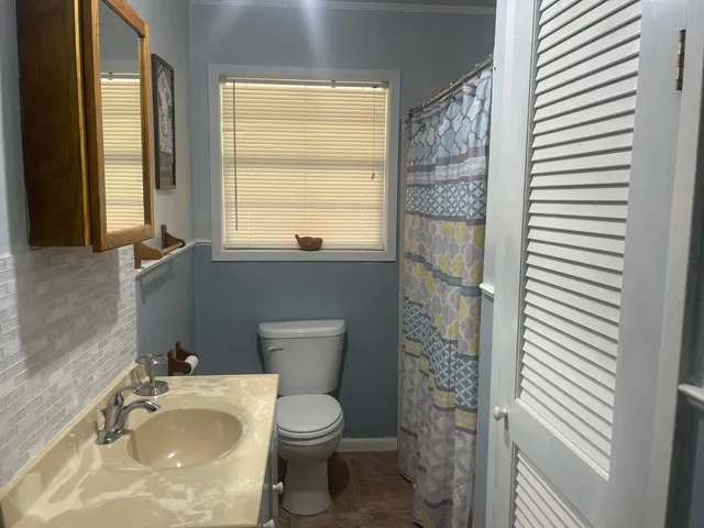 a bathroom with a toilet a sink and a window