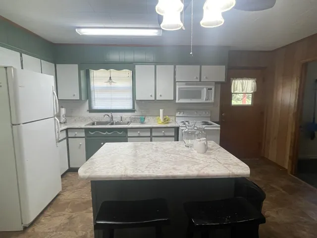 a kitchen with a table chairs refrigerator and microwave