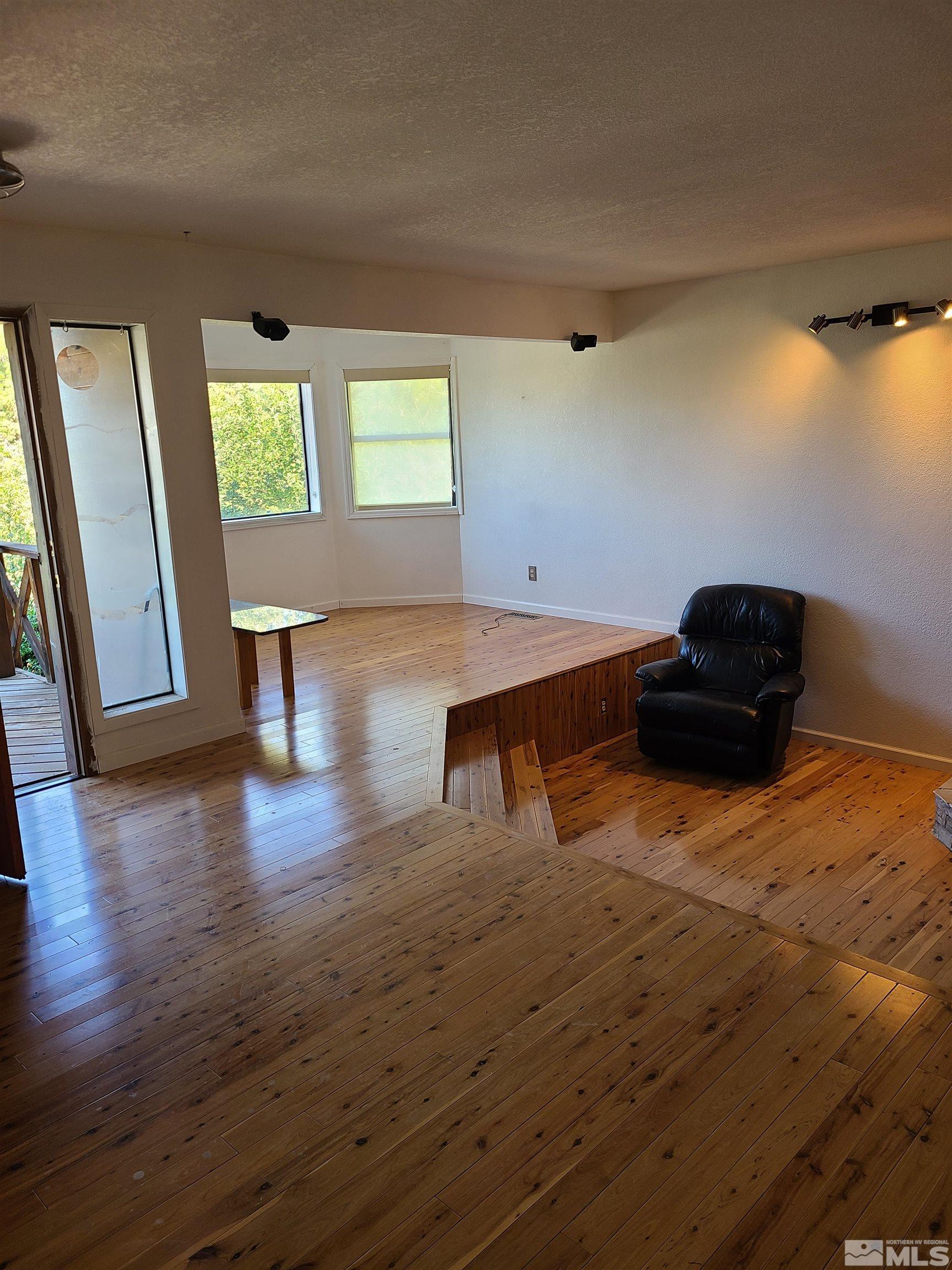 14460 Virginia Foothills Drive Reno, NV 89521 - Photo 8 of 17 a living room with wooden floor and potted plant