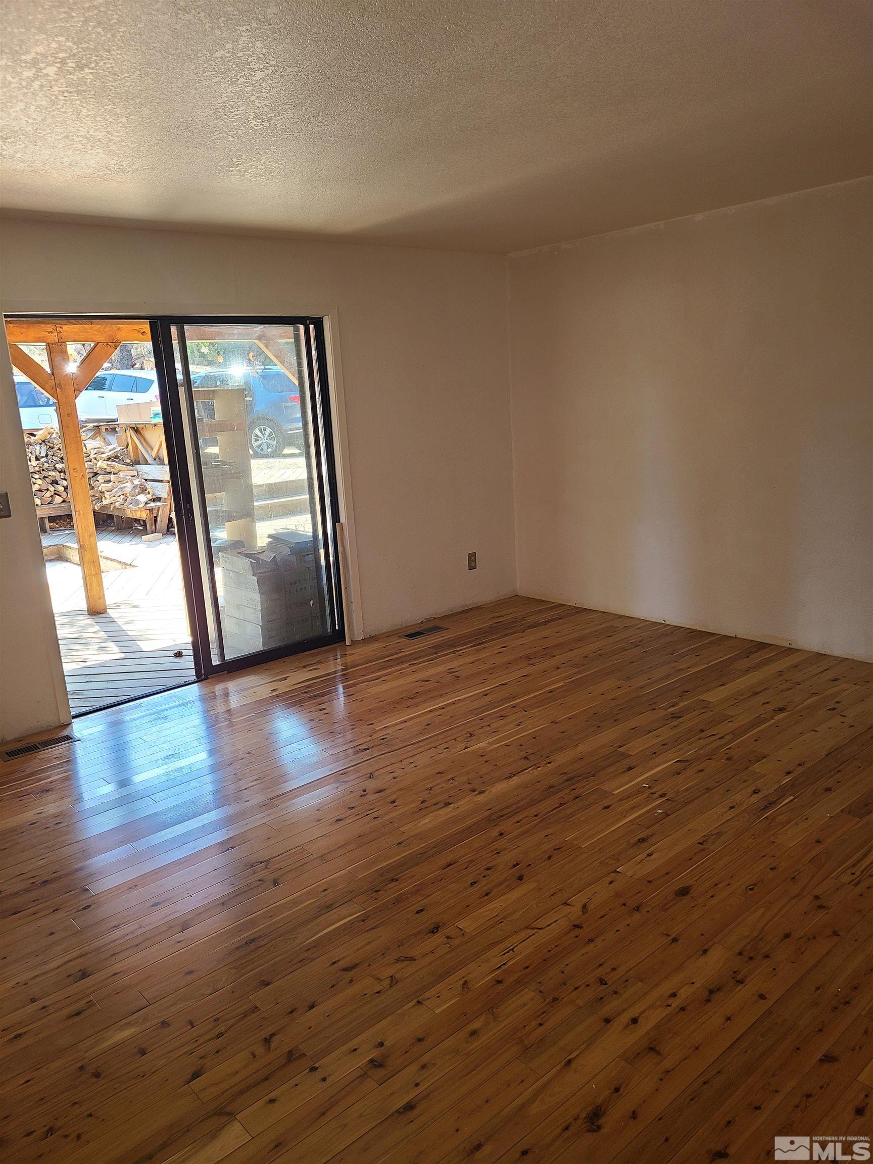 14460 Virginia Foothills Drive Reno, NV 89521 - Photo 9 of 17 a view of an empty room with wooden floor and a window