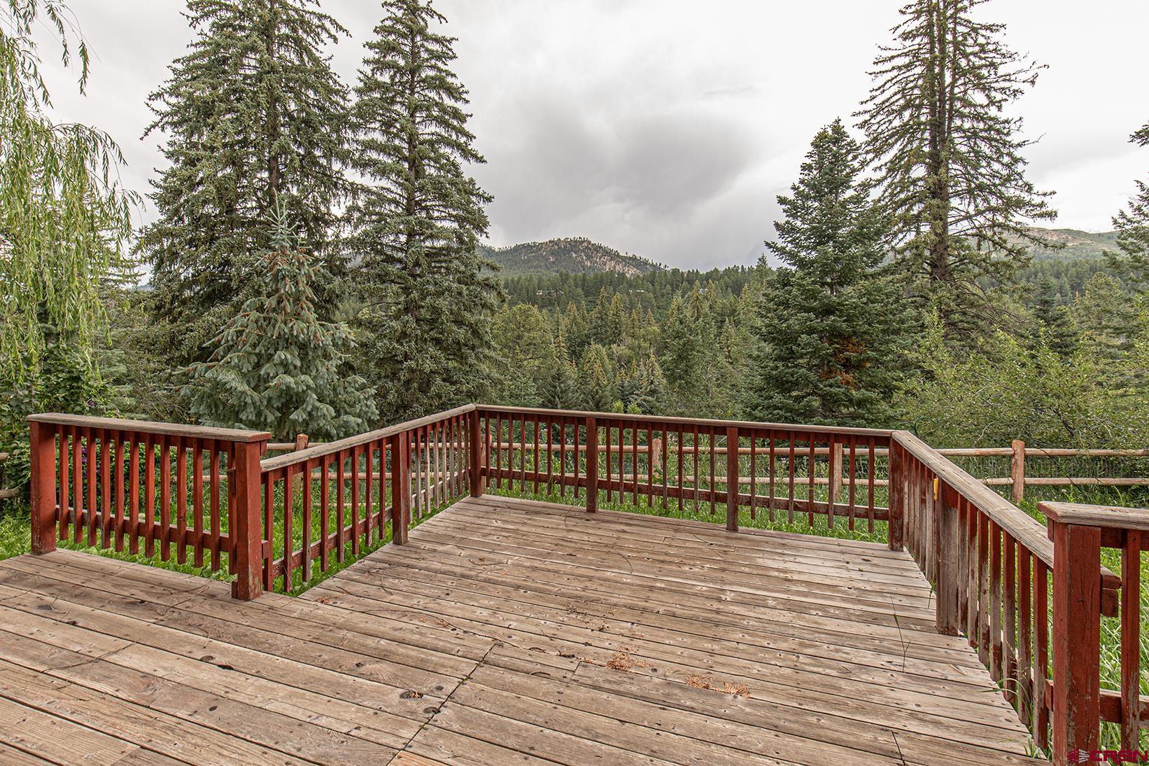 499 High Trails Drive Durango, CO 81301 - Photo 3 of 31 a balcony with wooden floor and trees in the background