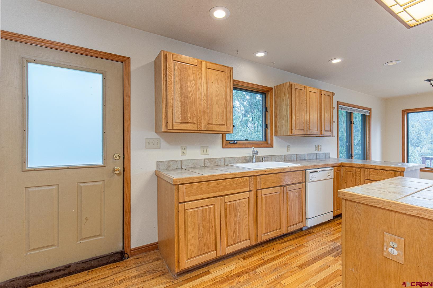 499 High Trails Drive Durango, CO 81301 - Photo 6 of 31 a kitchen with stainless steel appliances granite countertop a sink and cabinets with wooden floor