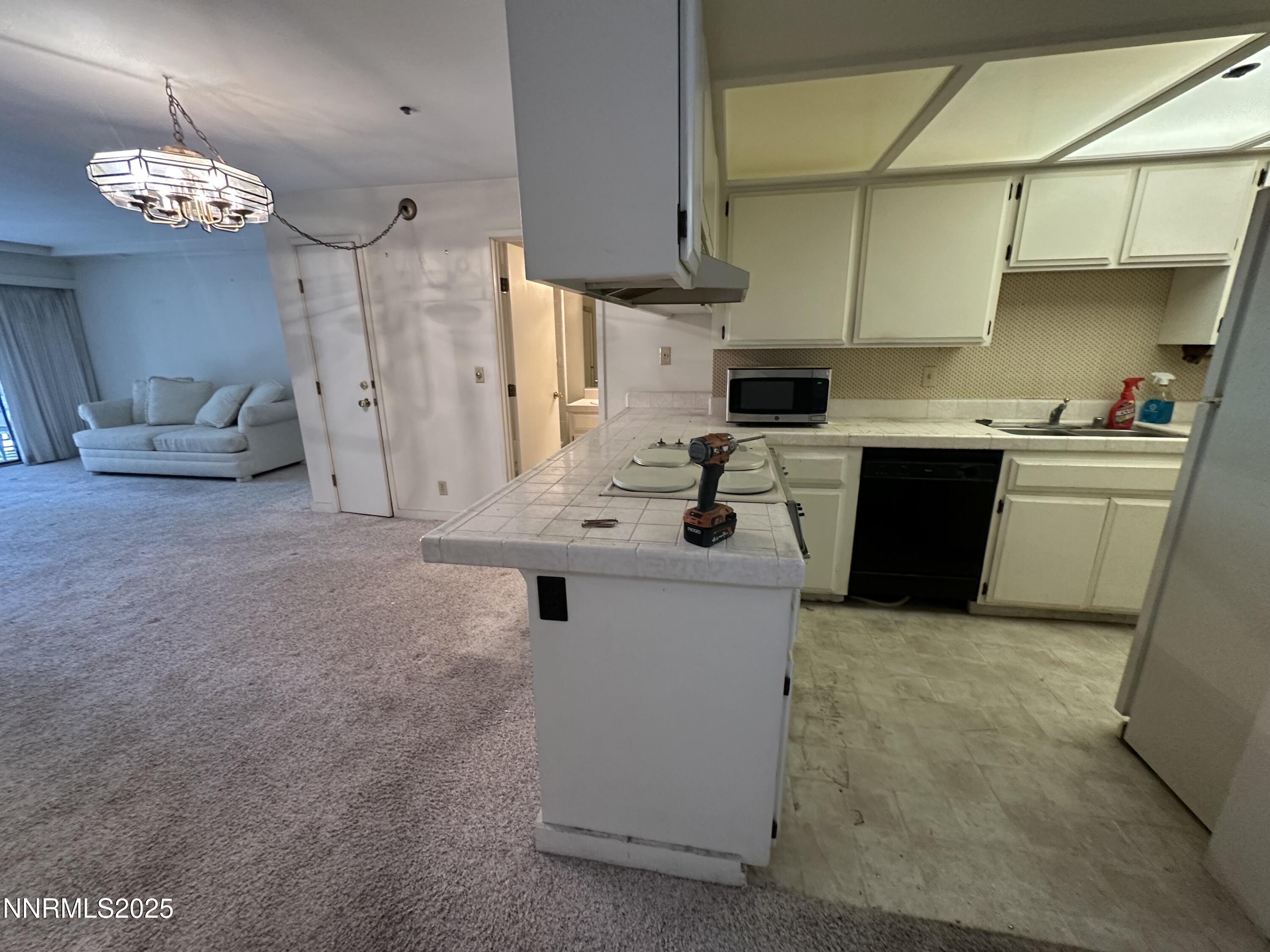 333 Ski Way, Unit 253 Incline Village, NV 89451 - Photo 4 of 13 a kitchen with a sink dishwasher a stove a microwave oven and a dining table with wooden cabinet