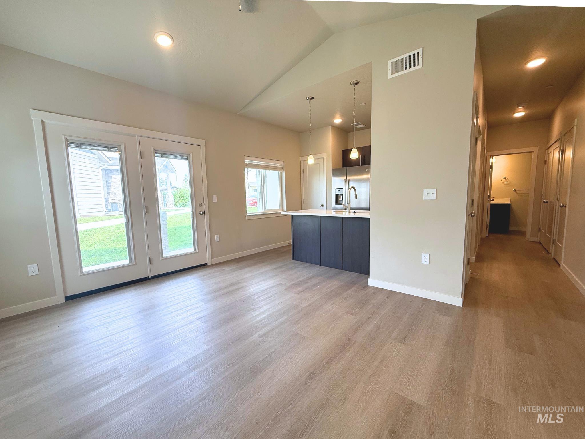 616 North 44th Street Nampa, ID 83687 - Photo 3 of 18 Unfurnished living room with vaulted ceiling, light wood-style flooring, and recessed lighting
