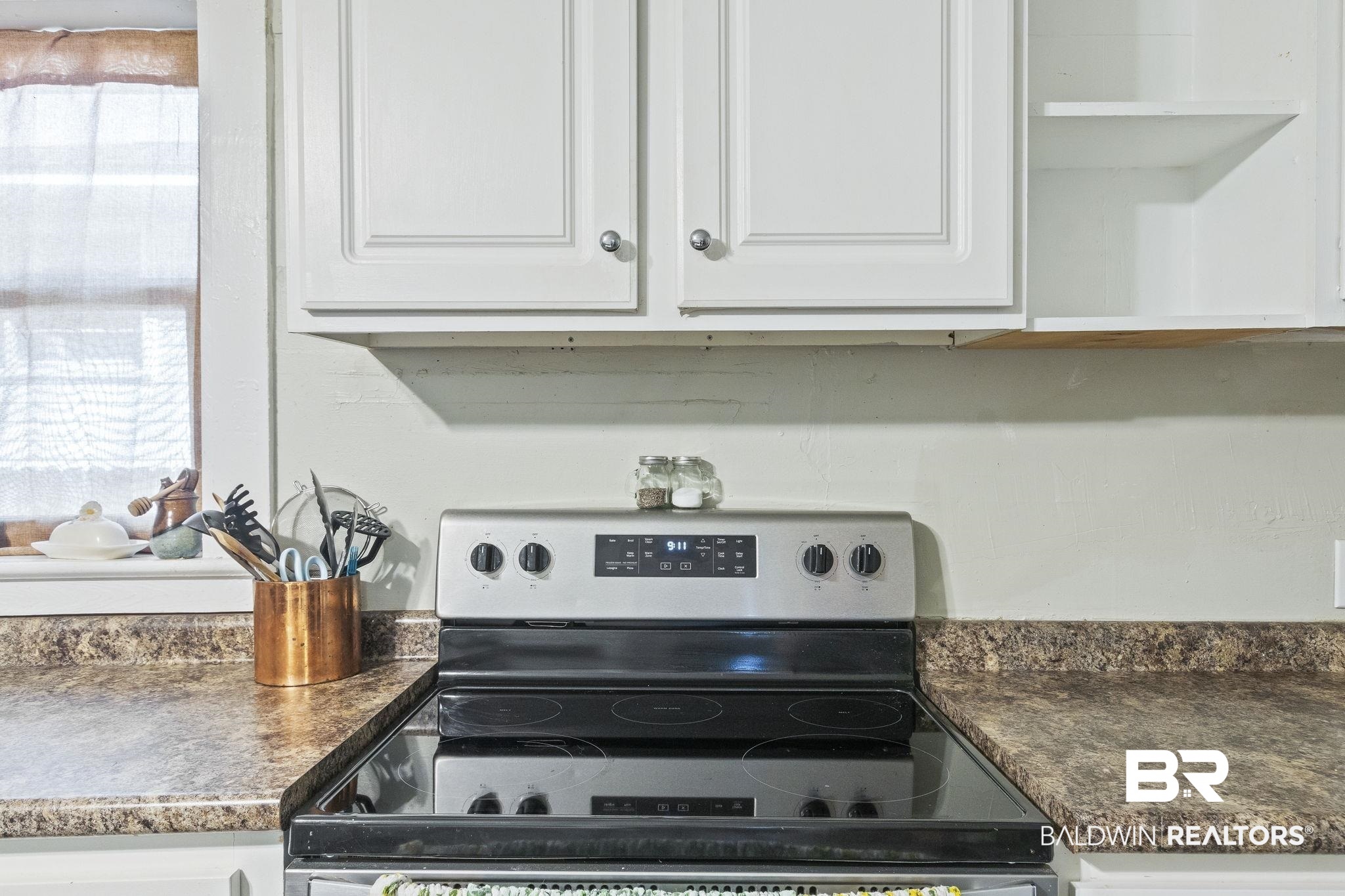 707 North Cedar Street Foley, AL 36535 - Photo 19 of 69 Kitchen featuring stainless steel range with electric cooktop and white cabinetry