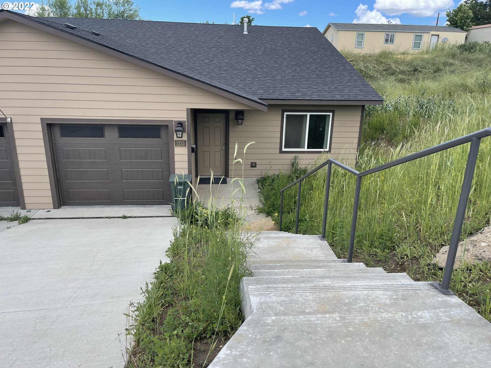 1235 Southwest 12th Street Pendleton, OR 97801 - Photo 2 of 17 a front view of a house with a yard and garage