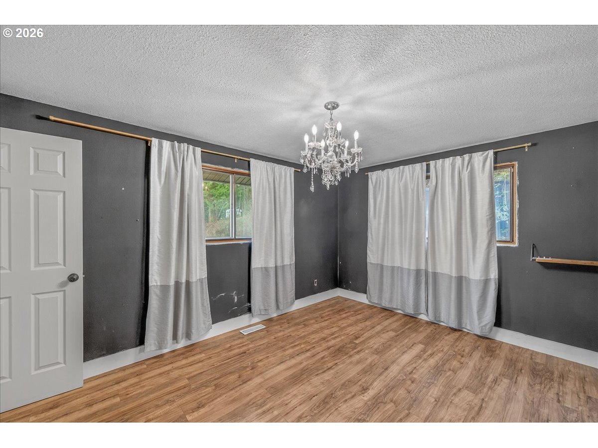 33320 Southeast Francis Street Gresham, OR 97080 - Photo 21 of 40 a bedroom with a large bed and a chandelier