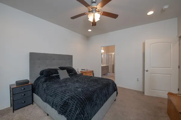 a bedroom with a large bed and a chandelier
