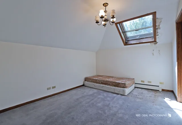 a view of an empty room with a chandelier fan and windows