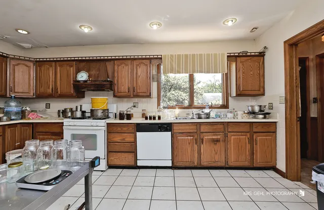 a kitchen with stainless steel appliances granite countertop a sink dishwasher stove top oven and cabinets