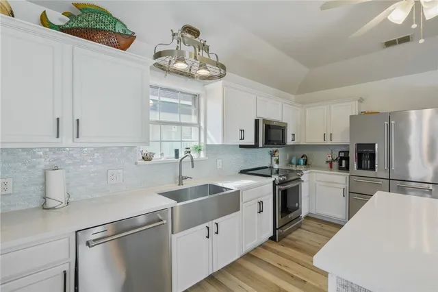 a kitchen with a sink a stove and cabinets