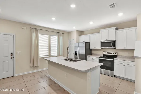 a kitchen that has a sink a stove and cabinets