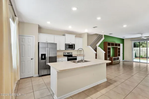 a kitchen with stainless steel appliances a refrigerator sink and cabinets