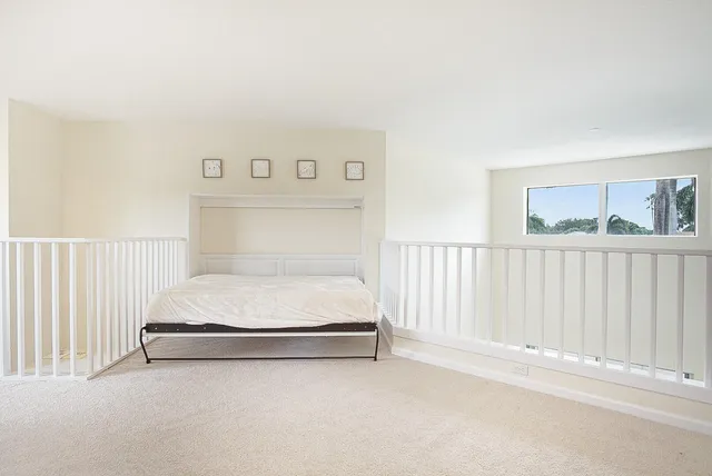 a bed sitting in a white room
