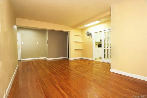a view of an empty room with wooden floor