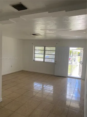 a view of a livingroom with an empty space and a window