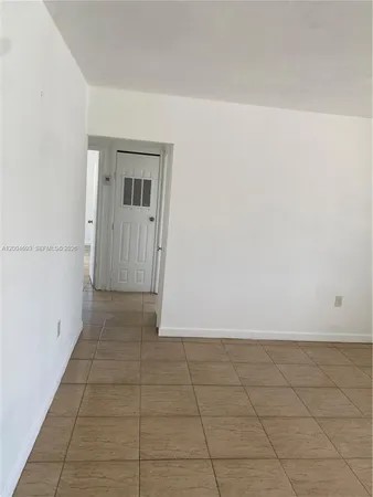 a view of a refrigerator in an empty room