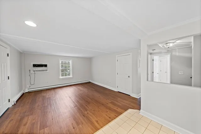 a view of a room with wooden floor and window