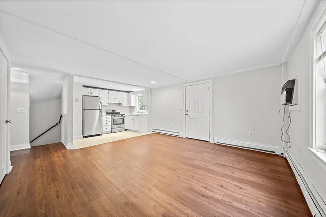 a view of a big room with wooden floor and a window