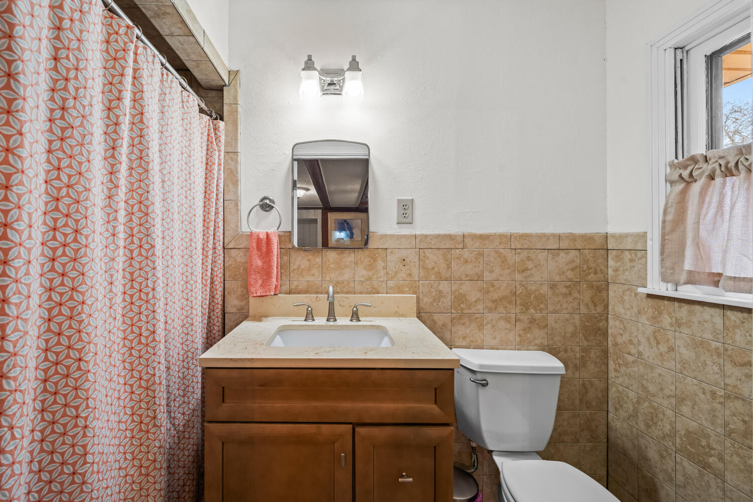 3104 26th Street Lubbock, TX 79410 - Photo 15 of 19 a bathroom with a toilet sink and mirror