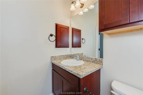 a bathroom with a granite countertop sink and a mirror