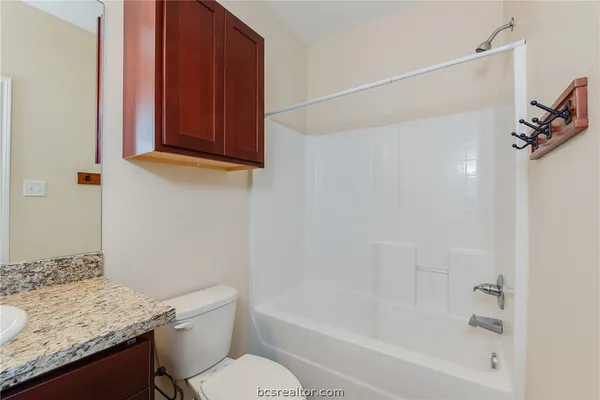 a bathroom with a granite countertop sink toilet and shower