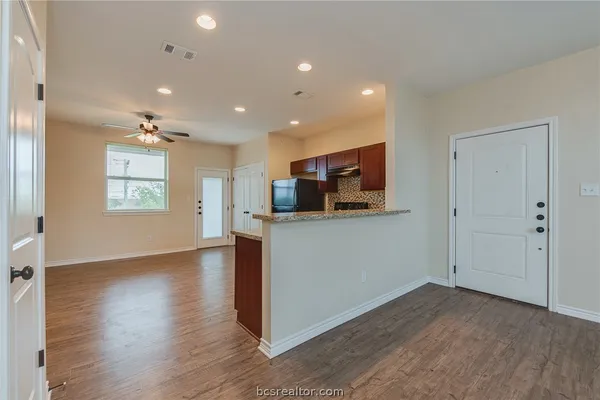 a view of empty room with wooden floor and windows