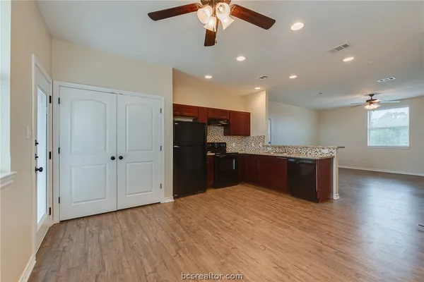 a kitchen with kitchen island granite countertop wooden floors and a sink