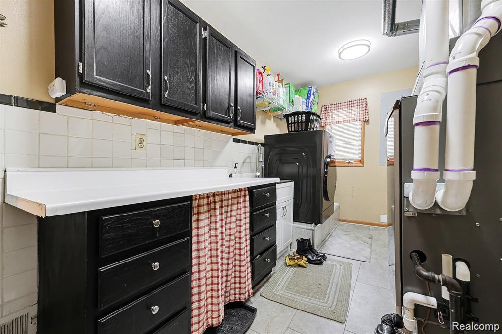 7277 Cardinal Road Algonac, MI 48001 - Photo 23 of 36 Laundry area featuring cabinet space, heating unit, washer / dryer, and light tile patterned flooring
