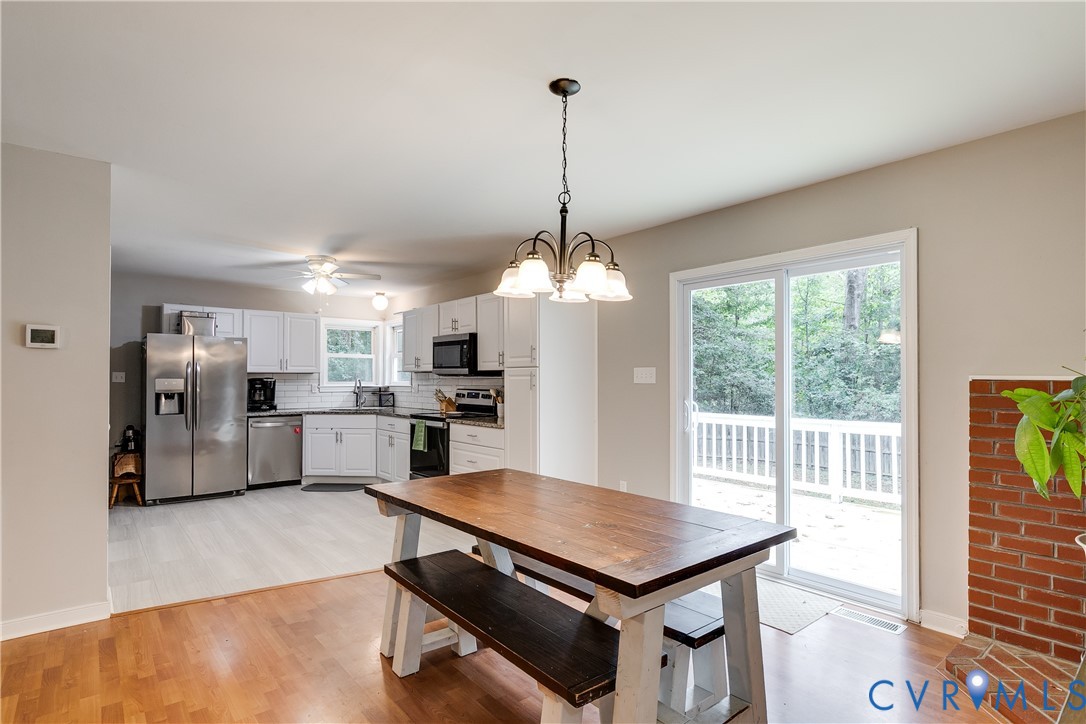1030 Rock Spring Road Bumpass, VA 23024 - Photo 11 of 34 a dining room with furniture a window and stainless steel appliances
