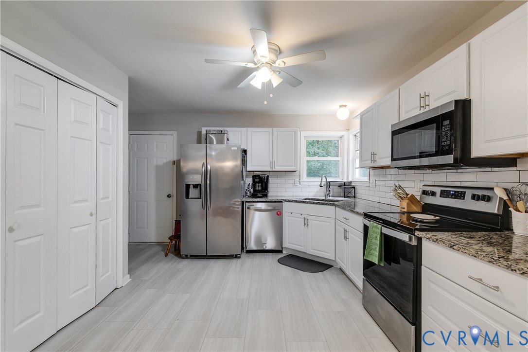 1030 Rock Spring Road Bumpass, VA 23024 - Photo 12 of 34 a kitchen with a sink stainless steel appliances and cabinets