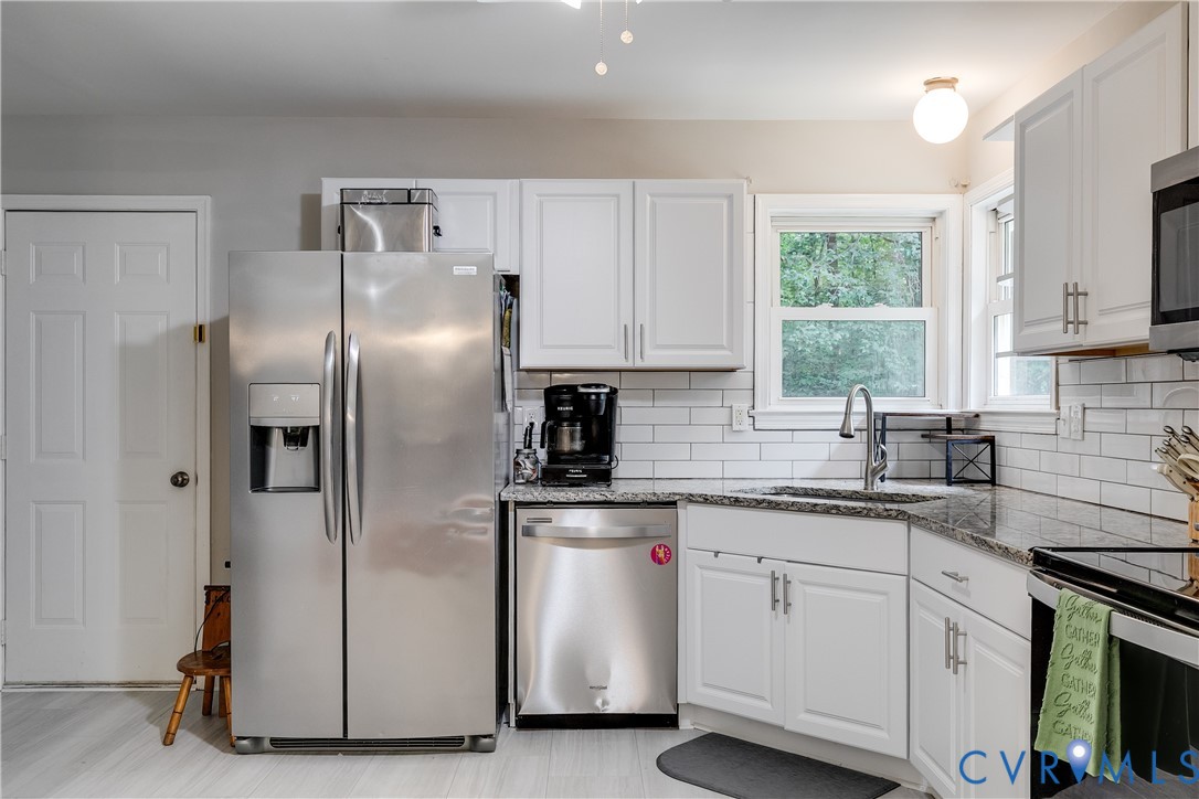 1030 Rock Spring Road Bumpass, VA 23024 - Photo 13 of 34 a kitchen with white cabinets and appliances