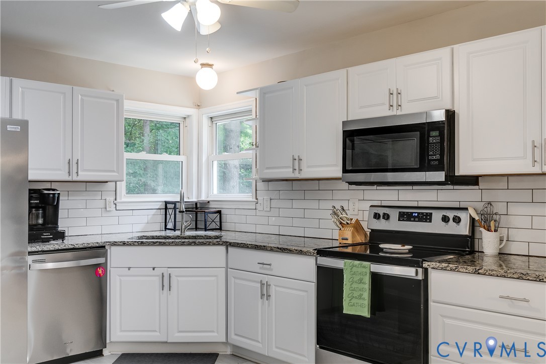 1030 Rock Spring Road Bumpass, VA 23024 - Photo 15 of 34 a kitchen with granite countertop white cabinets white stainless steel appliances a sink and a window