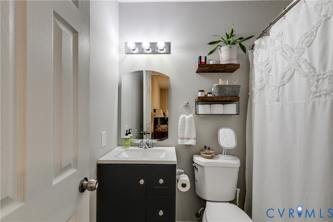1030 Rock Spring Road Bumpass, VA 23024 - Photo 19 of 34 a bathroom with a toilet sink and mirror