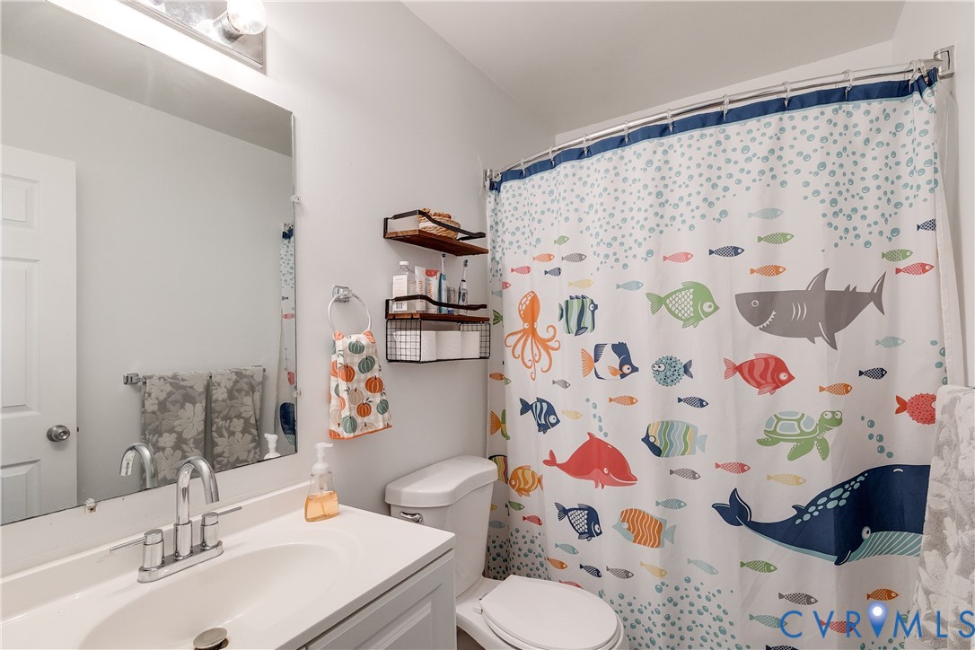1030 Rock Spring Road Bumpass, VA 23024 - Photo 23 of 34 a bathroom with a sink toilet and shower curtain