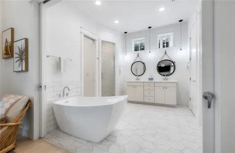 a bathroom with a white tub shower and mirror