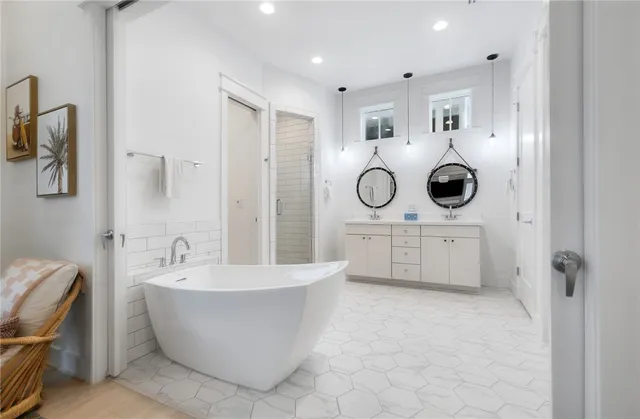 a bathroom with a white tub shower and mirror